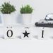 Minimalist desk setup with motivational blocks spelling 'Do It' and small potted plants.